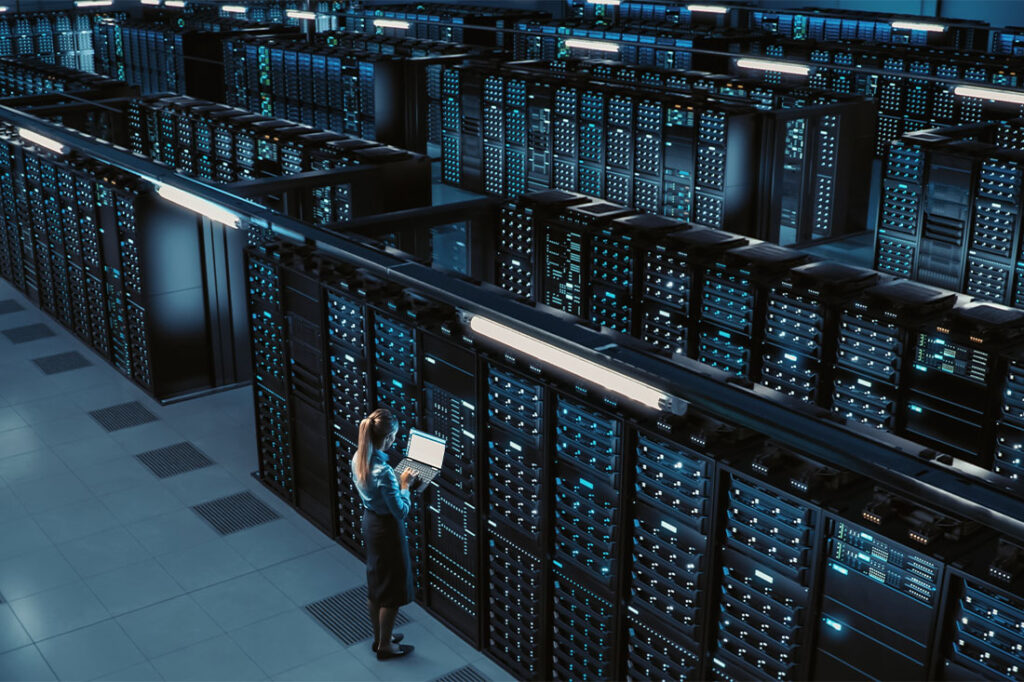 Woman using laptop in data center using laptop