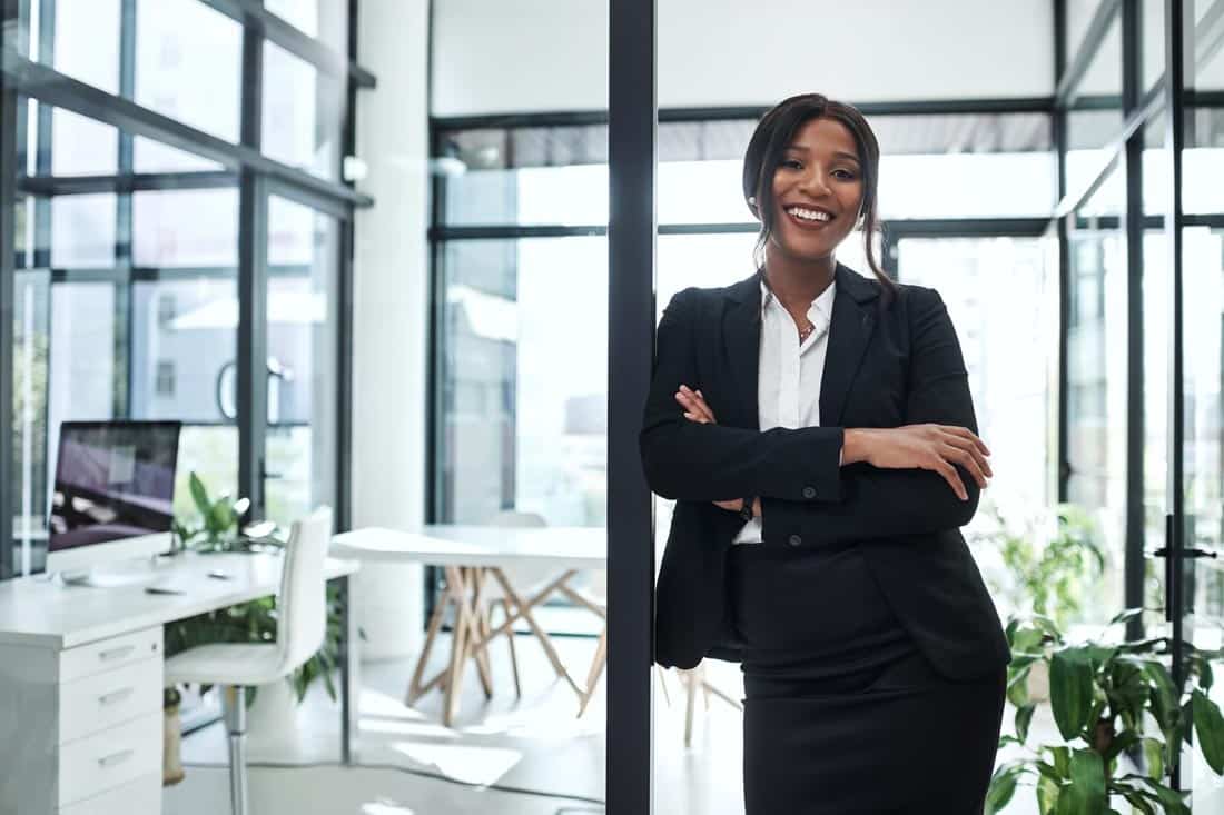 Smiling successful entrepreneur standing in a doorway