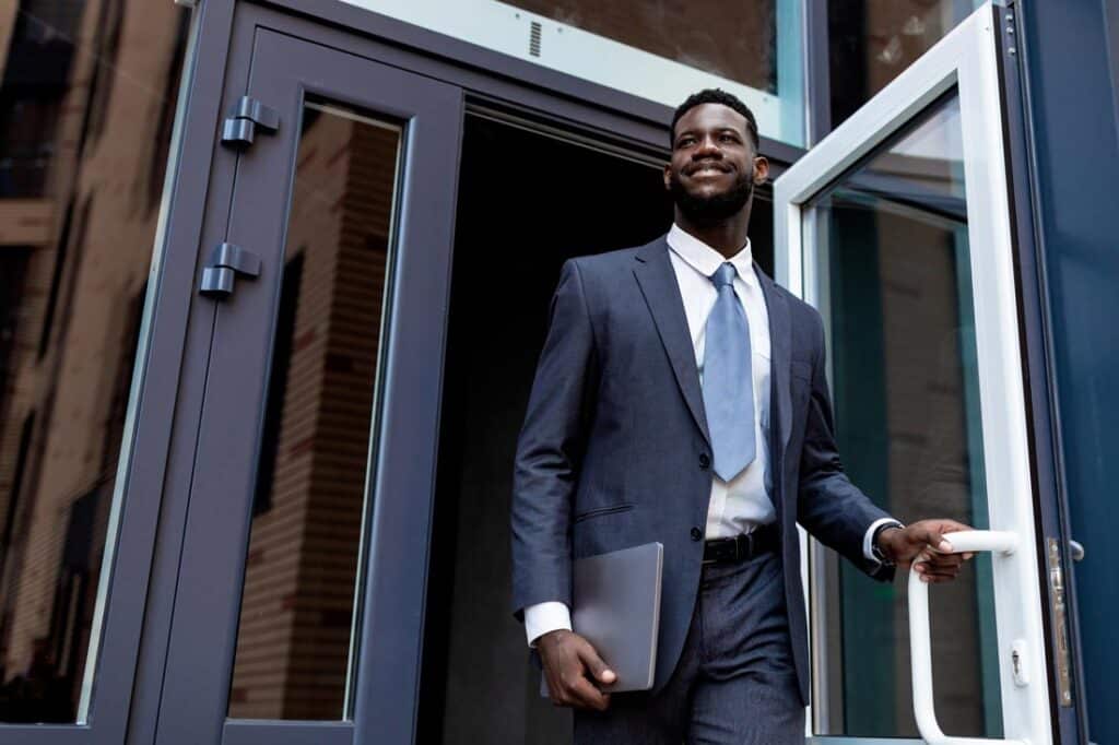 Professional leaving a building and smiling because he knew when to step down from a leadership role