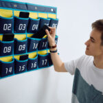 High school student leaving his smart phone in cell phone organizer on the wall before entering the classroom at school