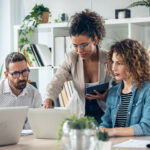 business team standing around computer for presentation of work in the office
