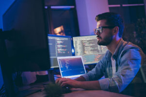 Profile side view portrait of man typing in dark room