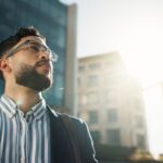 A professionally dressed man looking to the sun.