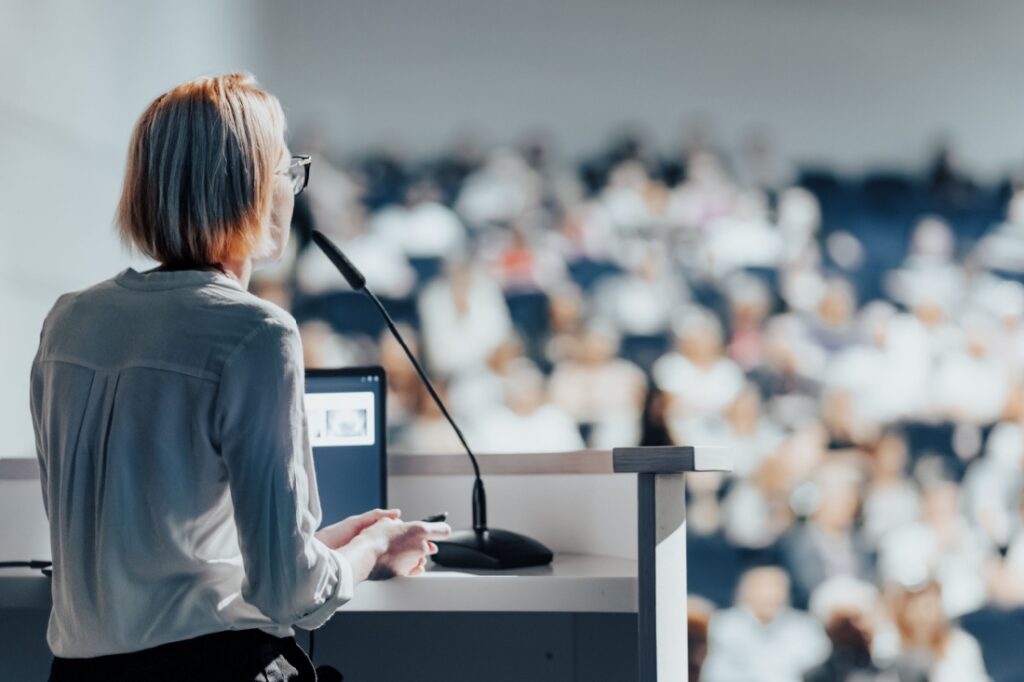 A female speaker in front of a crowd.