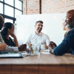 a boss sitting in an office and having a team meeting with employees