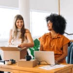 online store owners smiling while working together in their shop