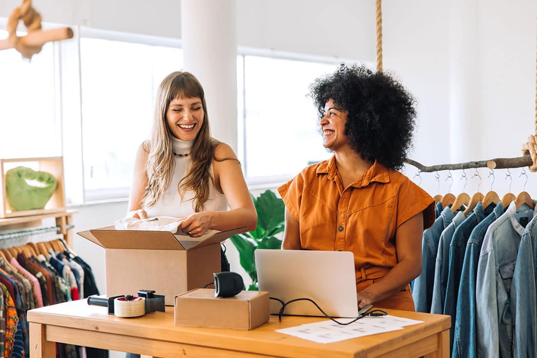 online store owners smiling while working together in their shop
