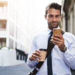 business man in city using his mobile phone