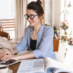 Gen Z woman typing on laptop while working or studying at home