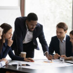 African American male boss work with diverse team at office meeting