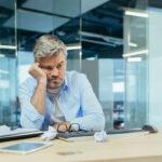 gray-haired man working in modern office at computer