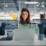 Happy Businesswoman Using Laptop Computer in Modern Office