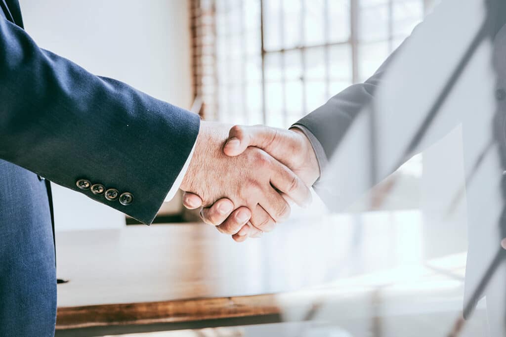 Two business men shaking hands in a business setting