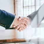 Two business men shaking hands in a business setting